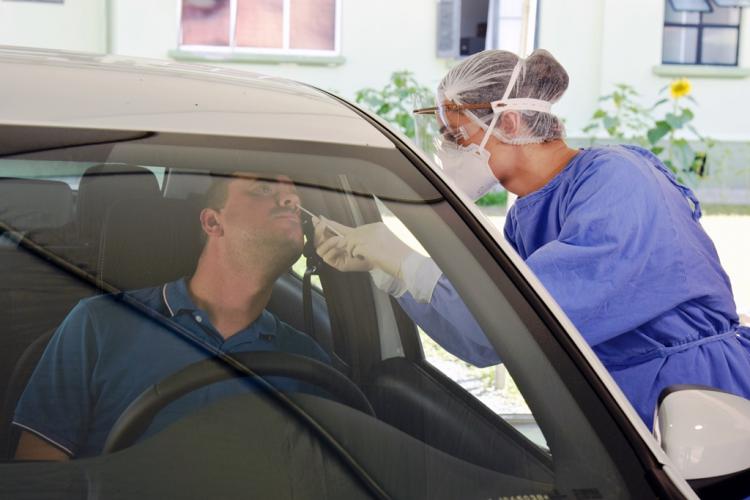 Exame sendo coletado dentro do carro da pessoa
