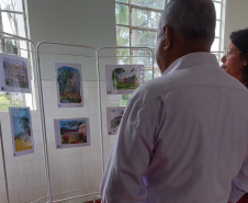 pessoas olhando para exposição de desenhos