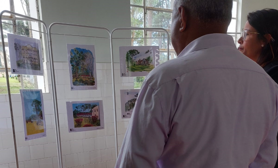 pessoas olhando para exposição de desenhos